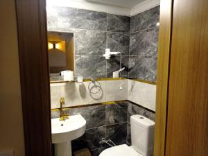 a bathroom with a toilet and a sink and a mirror at Grand Marrakech Hotel in Yıldırım