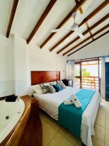 a bedroom with a large bed and a bath tub at Hotel Route 66 in Vichayito