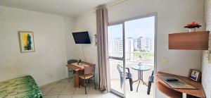 a living room with a room with a table and a window at Thermas Place by Esteves em Caldas in Caldas Novas