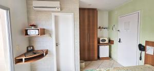 a room with a bed and a tv on a wall at Thermas Place by Esteves em Caldas in Caldas Novas