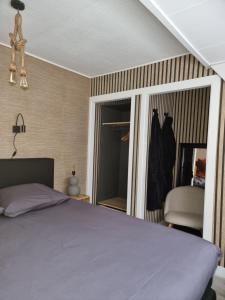 una camera con un letto e una sedia e una finestra di Logeren bij Sabine en JW a Beekbergen