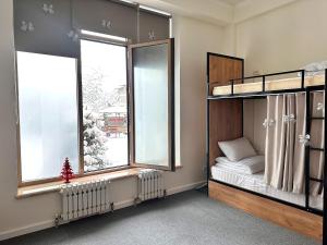 a bedroom with two bunk beds and two windows at Stay Hostel in Bishkek