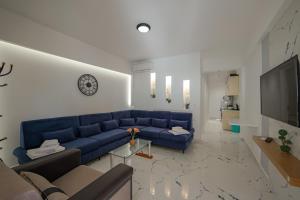 a living room with a blue couch and a television at Hotel Angjelo in Borsh