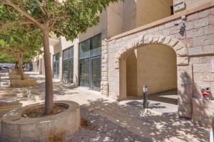 un bâtiment avec un arbre devant un bâtiment dans l'établissement 4Corners Retreat- Center of Town, Jerusalem, à Jérusalem