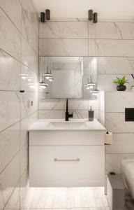 une salle de bain blanche avec un lavabo et un miroir dans l'établissement 4Corners Retreat- Center of Town, Jerusalem, à Jérusalem 14 autres photos