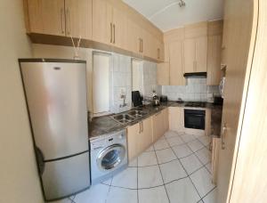 a kitchen with a refrigerator and a dishwasher at Garden Oasis Cottage in Windhoek