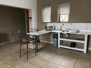 a kitchen with a counter and a table and chairs at Upstairs at the Miles’ in George