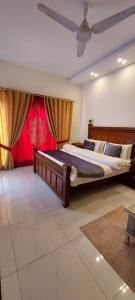 een grote slaapkamer met 2 bedden en een plafond bij RADIANT GUEST HOuSE 2 in Islamabad
