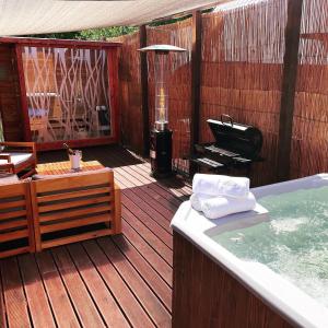 a deck with a hot tub and a grill at Osada Górski Potok in Szczawina