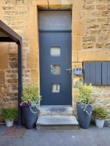 a blue door on a building with potted plants at Appartement, 2eme étage avec piscine partagée in Sedan