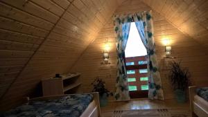 Cette chambre mansardée dispose d'une fenêtre et d'un lit. dans l'établissement Rancho Zapole, à Zasadne