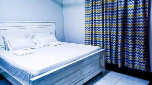 een bed met twee kussens en een gordijn in een kamer bij One Bedroom at Bamburi in Mombasa