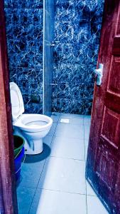 een badkamer met een toilet en een blauwe muur bij One Bedroom at Bamburi in Mombasa