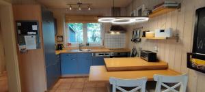 苏索Seemöwe 1的配有蓝色橱柜和木桌的厨房 更多19张照片