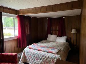 een slaapkamer met een bed en een raam bij Family Cabin at Rainier Lodge -0.4 m from entrance in Ashford