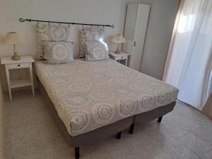 Casa Rochinha في بورتيماو: سرير في غرفة نوم مع طاولتين ومصباحين