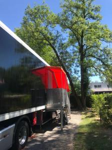 Sleeptrailer في زيورخ: شاحنة حمراء متوقفة بجانب شجرة