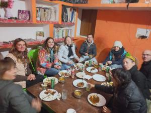 un grupo de personas sentadas alrededor de una mesa comiendo comida en Orchha Best Homestay, en Orchha