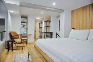 um quarto com uma grande cama branca e uma secretária em Roma Apartment with Private Terrace in CDMX em Cidade do México