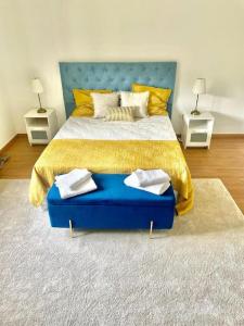 a bedroom with a large bed with a blue headboard at LouriVillage in Bombarral