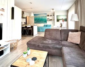 ein Wohnzimmer mit einem Sofa und einem Tisch in der Unterkunft Luxe Duinsuite in Groet