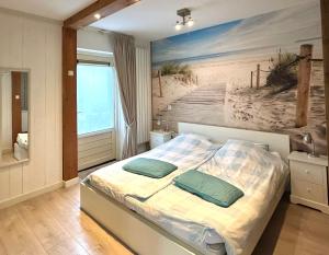 Schlafzimmer mit einem Bett mit Wandgemälde in der Unterkunft Luxe Duinsuite in Groet