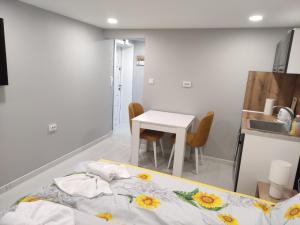 a bedroom with a bed and a table with chairs at MiniMo in Ruse