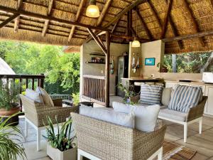 un patio al aire libre con sillas de mimbre y un bar en Malinga GuestHouse en Sandton