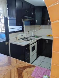 CASA HUAXYACAC في مدينة أواكساكا: مطبخ بدولاب سوداء وفرن علوي موقد أبيض