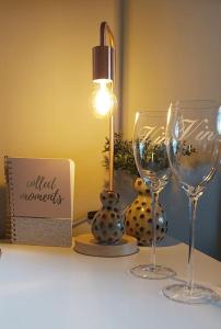 dos copas de vino y una lámpara en un estante en Tiny House Tholen, en Tholen