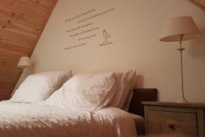 a bedroom with a bed with a writing on the wall at Tiny House Tholen in Tholen