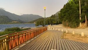 a wooden bridge over a river next to a body of water at Cabañas Villa Elfo in Futrono