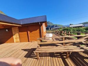 a deck with wooden benches on top of a house at Cabañas Villa Elfo in Futrono
