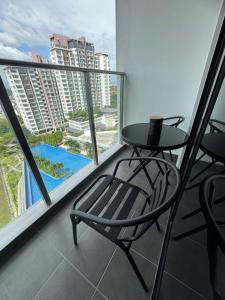 una mesa y una silla en un balcón con vistas a la piscina en CT View Homestay by Ifaizal, Presint 15 Putrajaya, en Putrajaya