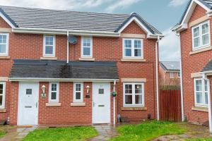 a red brick house with a white garage at Pacific House in Thornaby on Tees