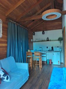 a living room with a blue couch and a kitchen at Pousada Hoff Haus in Pomerode