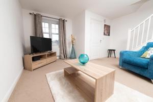 a living room with a blue couch and a tv at Pacific House in Thornaby on Tees