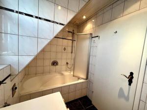 a bathroom with a tub and a person standing next to it at Wohnung in Greven - nähe Münster in Greven