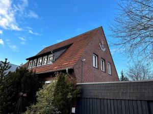 ein Backsteingebäude mit einem Dach über einem Zaun in der Unterkunft Wohnung in Greven - nähe Münster in Greven