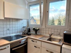 eine Küche mit einem Waschbecken und zwei Fenstern in der Unterkunft Wohnung in Greven - nähe Münster in Greven