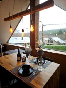 un tavolo in legno con piatti e bicchieri e una finestra di Le Haut' Mont a Manhay