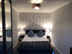 a bedroom with a bed with blue pillows and a mirror at Above the harbour wick in Wick