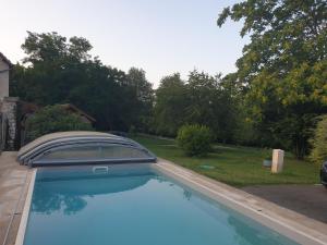 una gran piscina azul en un patio en La Casa D'Augy logement du rez de Jardin, en Farges-en-Septaine