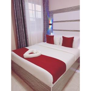 a bedroom with a large bed with red pillows at Mt. Everest Hotel in Kisii