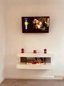 a tv hanging on a wall with a fireplace at AVA PROPERTY RENTALS in Făgăraş