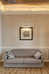 un sofá en una sala de estar con una pintura en la pared en Art Apartment Luxury Tintori Suite, en Florencia