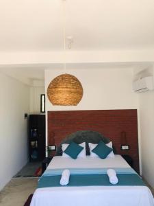 a bedroom with a large bed with blue pillows at Waves cabana kalametiya in Ranna