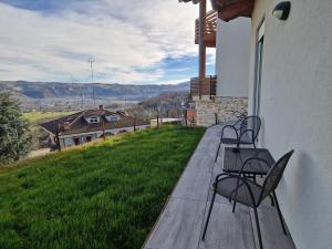 two chairs sitting on a porch with a view of a house at Villa Cocuzza in Piozzo