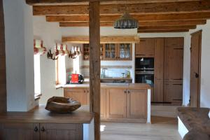 uma cozinha com armários de madeira e uma bancada em Ferienhaus Gompitzer em Heiligenblut