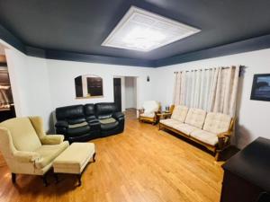 a living room with a black couch and chairs at Chalet Pakingan Gaspesie Cap-Chat in Cap-Chat